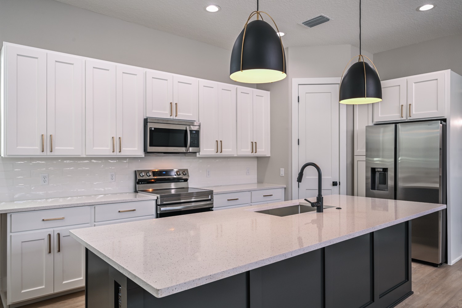 Custom kitchen with white cabinetry and quartz island built by Talbot Custom Homes in Orlando, Florida